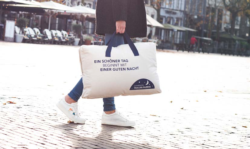 Woman carrying a canvas duvet bag